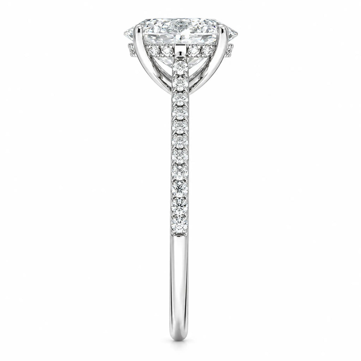 Side profile of oval moissanite engagement ring with four-prong setting and pavé band