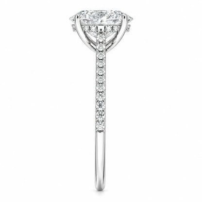 Side profile of oval moissanite engagement ring with four-prong setting and pavé band