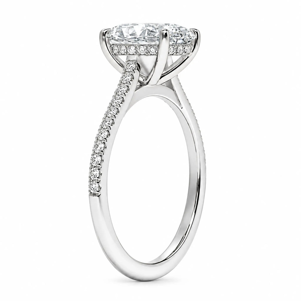 Setting detail of oval moissanite ring showing elevated four-prong basket and pavé band