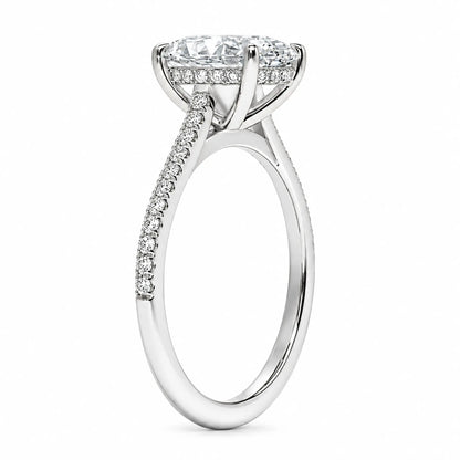 Setting detail of oval moissanite ring showing elevated four-prong basket and pavé band