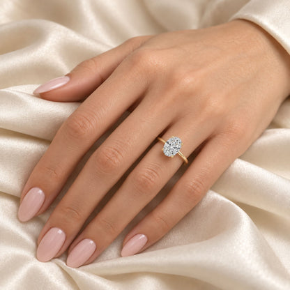 Yellow gold plated oval moissanite ring worn with a soft nude manicure