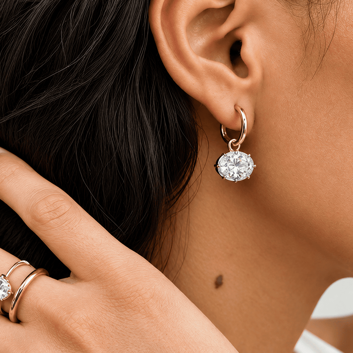 model wearing an ANNXMEE Iconic two-tone hoop earring with a horizontal oval moissanite drop