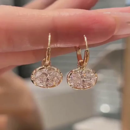 ANNXMEE Iconic two-tone oval moissanite hoop earrings shown from different angles, highlighting the stones’ sparkle and setting details.